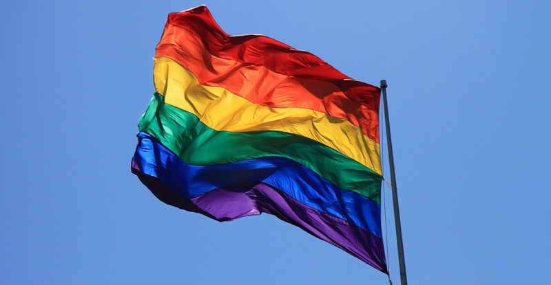 Kuvassa on liehuva värikäs Pride-lippu